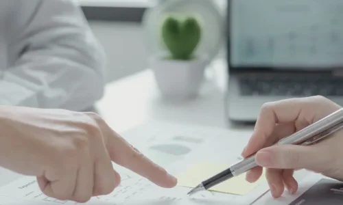 One-to-One Personal Coaching for Professionals Seeking Career Growth One-to-one personal coaching session showing hands pointing at business strategy documents during a focused career development consultation